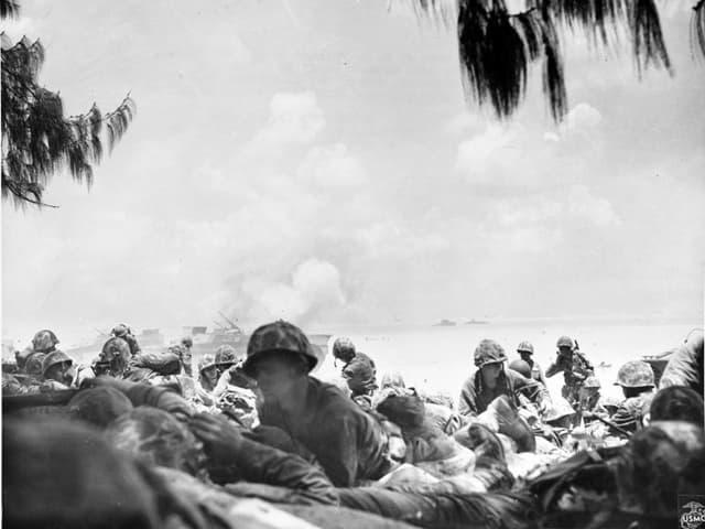 1944年6月、サイパン侵攻でアメリカ海軍の最初の侵攻部隊（海兵隊）が海岸沿いに陣取っている写真（出典：Naval History and Heritage Command）