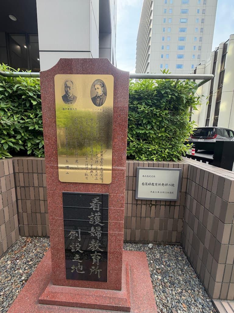 慈恵医大病院看護専門学校の前にある「看護婦教育発祥の地」の碑。大山捨松がバザーで得た収益を献金して創設された日本初の看護婦学校ができた場所。
